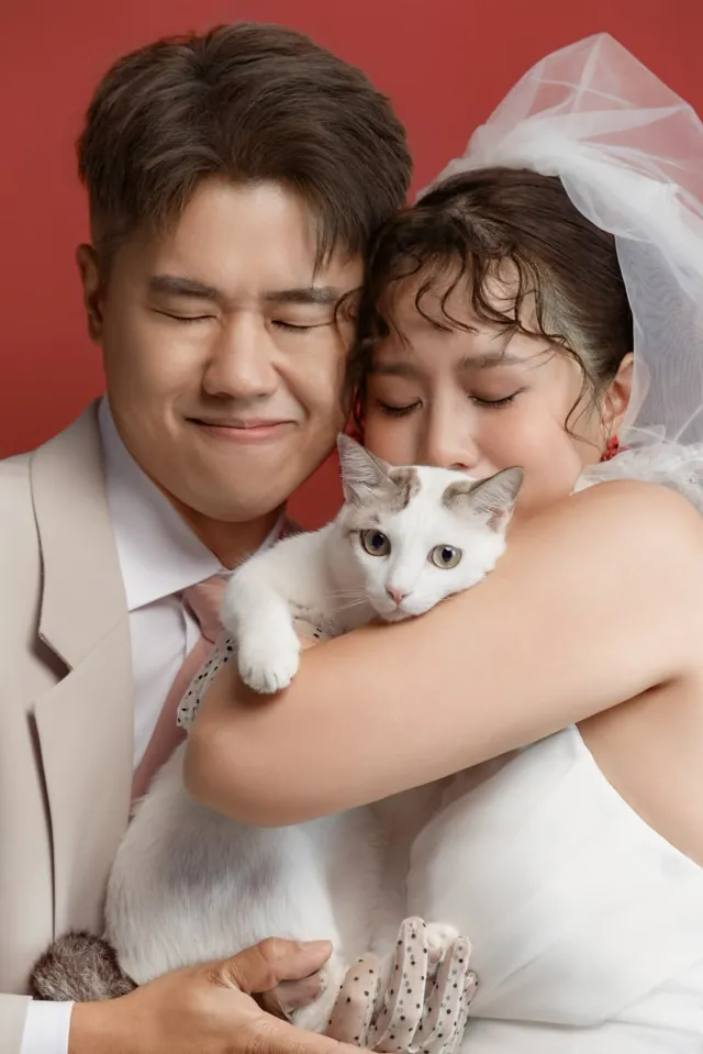 Chan and Stella hugging their cat